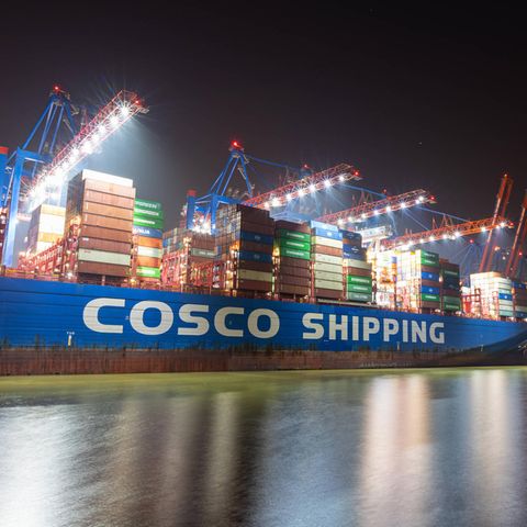 Ein Containerschiff von Chinas Staatskonzern Cosco bei Nacht im Hamburger Hafen