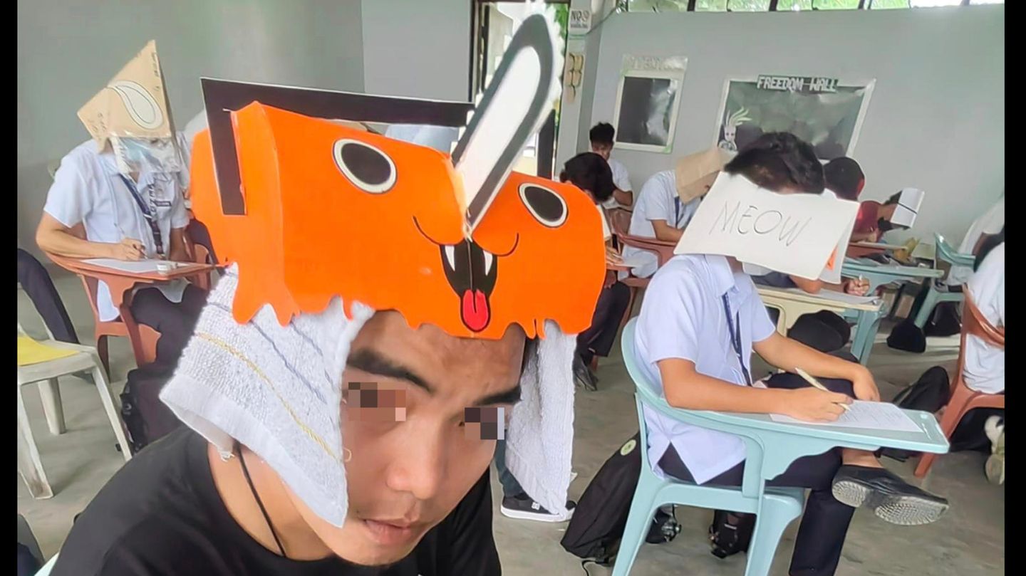 Ein Student auf den Philippinen trägt einen lustigen Hut bei einer Prüfung