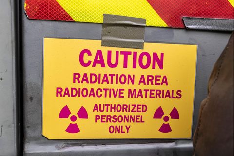 Ein rot-gelbes Schild mit der Aufschrift: "Caution. Radiation Area. Radioactive Materials. Authorized Personnel Only"