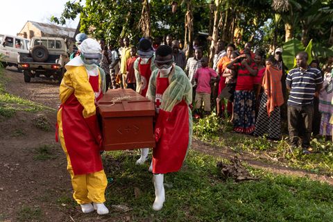Mitarbeiter des ugandischen Roten Kreuzes tragen einen Sarg mit einem Ebola-Opfer während einer Beerdigung