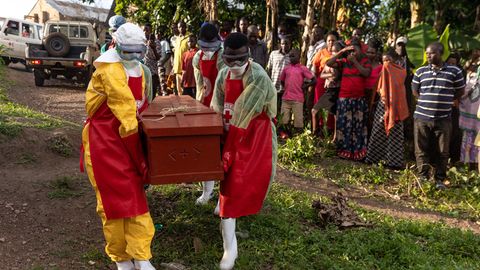 Mitarbeiter des ugandischen Roten Kreuzes tragen einen Sarg mit einem Ebola-Opfer während einer Beerdigung