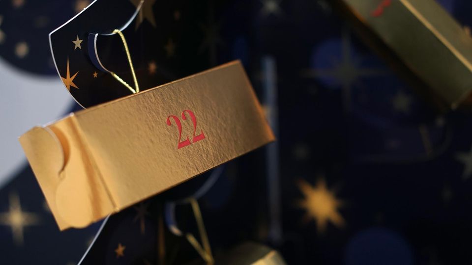 Am Weihnachtsbaum hängen 24 goldene Pakete in unterschiedlichen Größen und Formen.