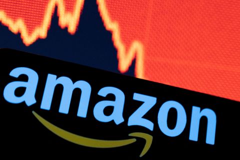 Das Amazon-Logo vor einem Graphen eines sinkenden Aktienkurses