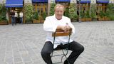 Schuhbeck sitzt vor dem Restaurant Südtiroler Stuben