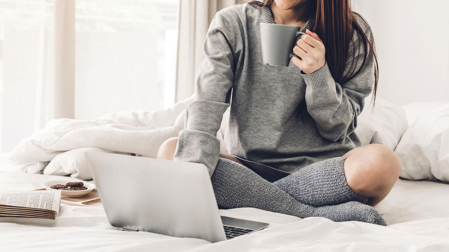 Chromebook vs. Laptop: Eine Frau sitzt mit Laptop auf der Couch