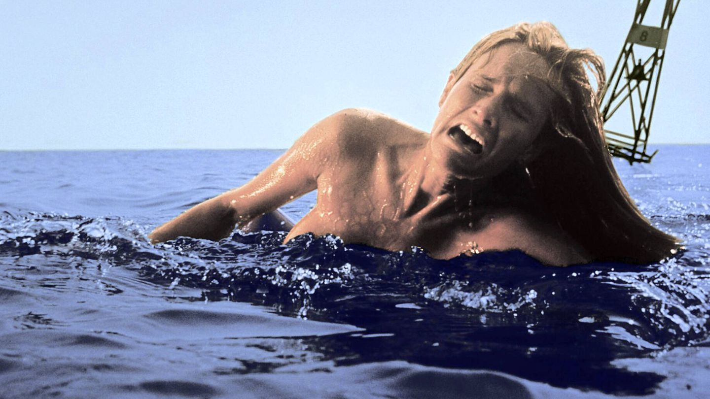 Eine Frau schwimmt im Wasser, ihr Gesicht ist schmerzverzerrt Eine Frau schwimmt im Wasser, ihr Gesicht ist schmerzverzerrt