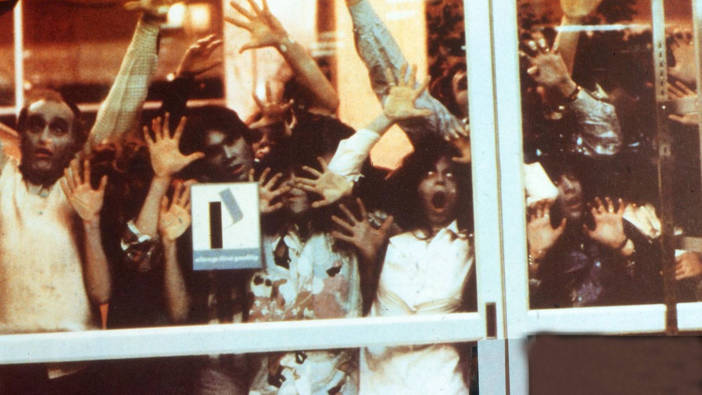 Zombies stehen an einer Glastür