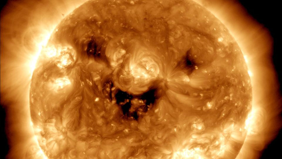 Die dunklen Flecken – sogenannte koronale Löcher – geben der Sonne den Anschein, als würde sie in die Kamera lachen