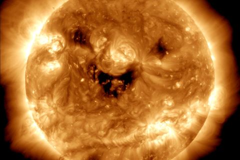 Die dunklen Flecken – sogenannte koronale Löcher – geben der Sonne den Anschein, als würde sie in die Kamera lachen