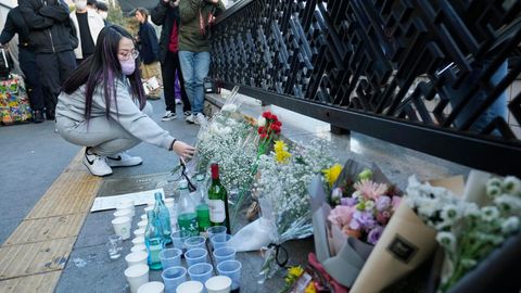 Eine Frau legt einen Blumenstrauß zum Gedenken an die Opfer des tödlichen Massenunglücks ab