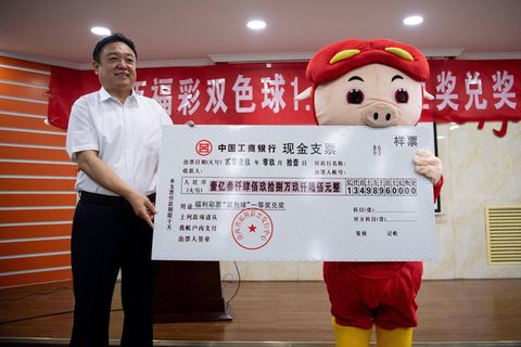 Lottogewinner nimmt seinen Preis in China verkleidet entgegen.