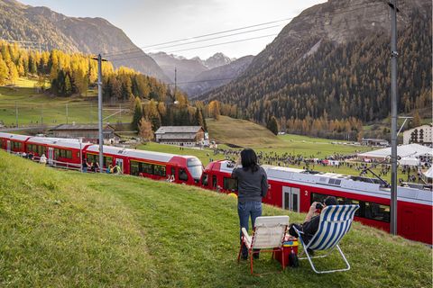 Ein Paar sitzt in Liegestühlen oberhalb der Bahnstrecke, auf der der Rekord-Zug in der Schweiz fährt