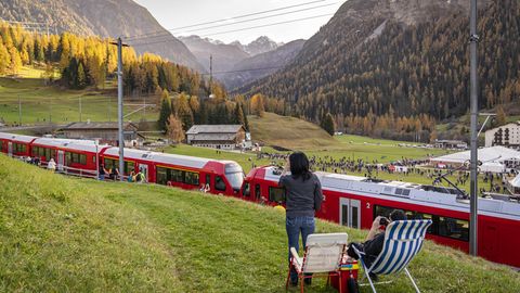 Ein Paar sitzt in Liegestühlen oberhalb der Bahnstrecke, auf der der Rekord-Zug in der Schweiz fährt