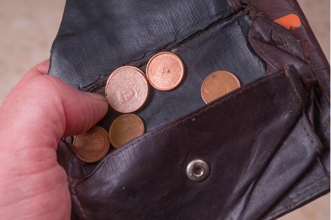 Die letzen Cent Münzen werden aus einem fast leeren portemonnaie geholt