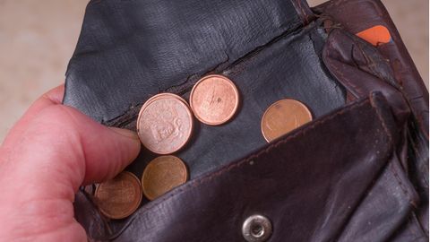 Die letzen Cent Münzen werden aus einem fast leeren portemonnaie geholt