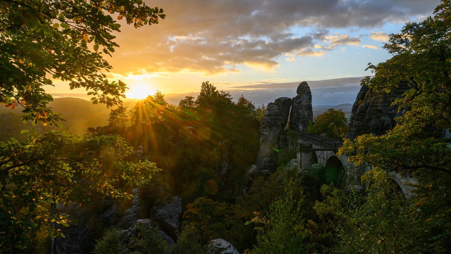 Morgenidylle: Die Sonne geht über dem Nationalpark Sächsische Schweiz mit der Basteibrücke auf.
