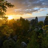 Morgenidylle: Die Sonne geht über dem Nationalpark Sächsische Schweiz mit der Basteibrücke auf.