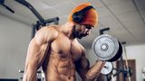 Ein Mann stemmt im Fitnessstudio Gewichte.