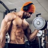 Ein Mann stemmt im Fitnessstudio Gewichte.