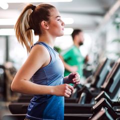 Eine Frau trainiert auf einem Laufband