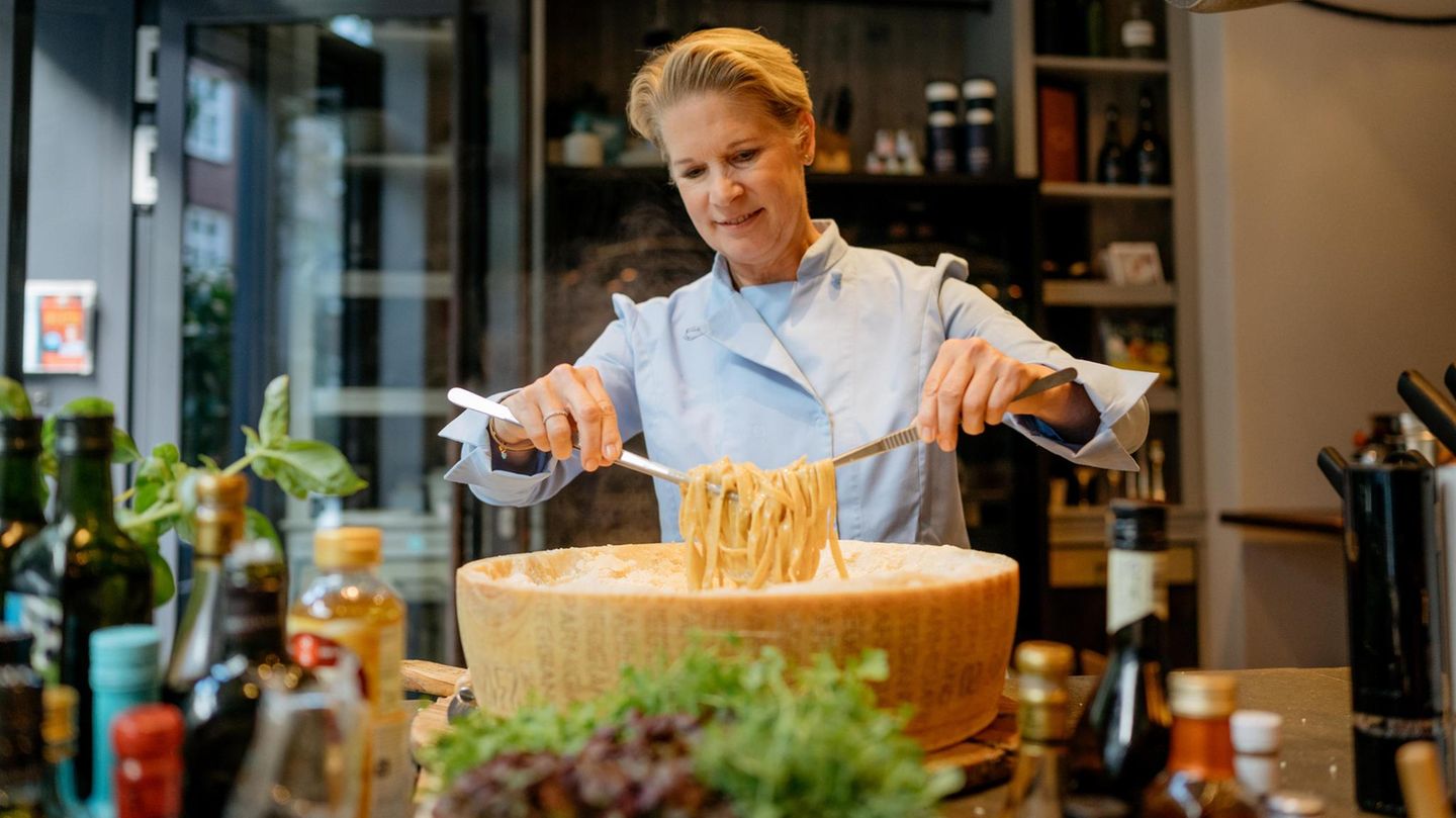 Cornelia Poletto wendet Pasta in einem riesigen Parmesanlaib