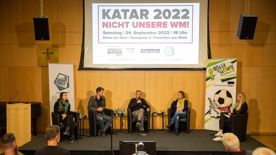 Auf einer Bühne sitzen vier Menschen bei einer Gesprächsrunde im Rahmen des Aktionstages "Nicht unsere WM"