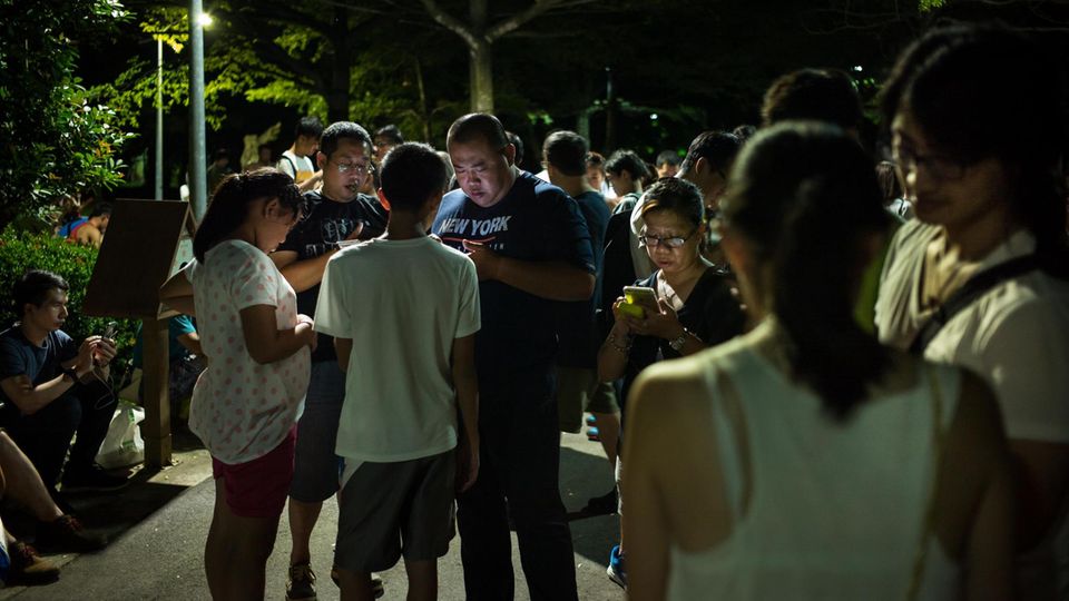 Menschen schauen in Taiwan auf ihre Handys
