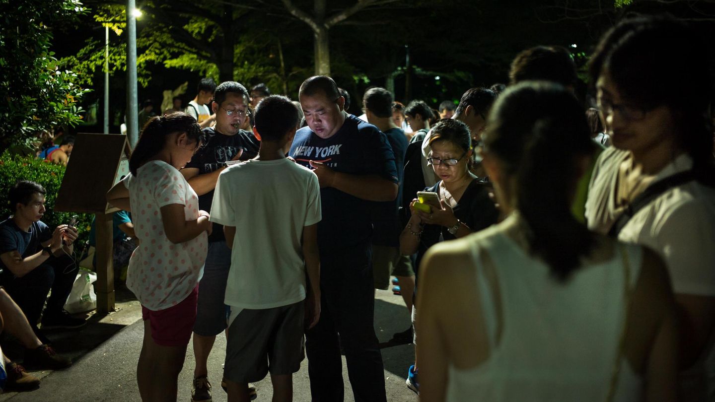Menschen schauen in Taiwan auf ihre Handys Menschen schauen in Taiwan auf ihre Handys