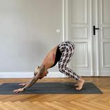 Jelena Lieberberg im herabschauenden Hund mit gebeugten Knien