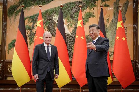 Chinas Präsident Xi Jinping (r) begrüßt den Kanzler