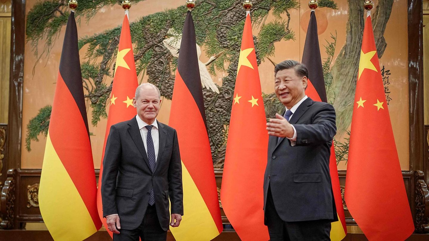 Chinas Präsident Xi Jinping (r) begrüßt den Kanzler