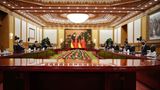 Xi Jinping und Olaf Scholz sitzen an einem großen Tisch