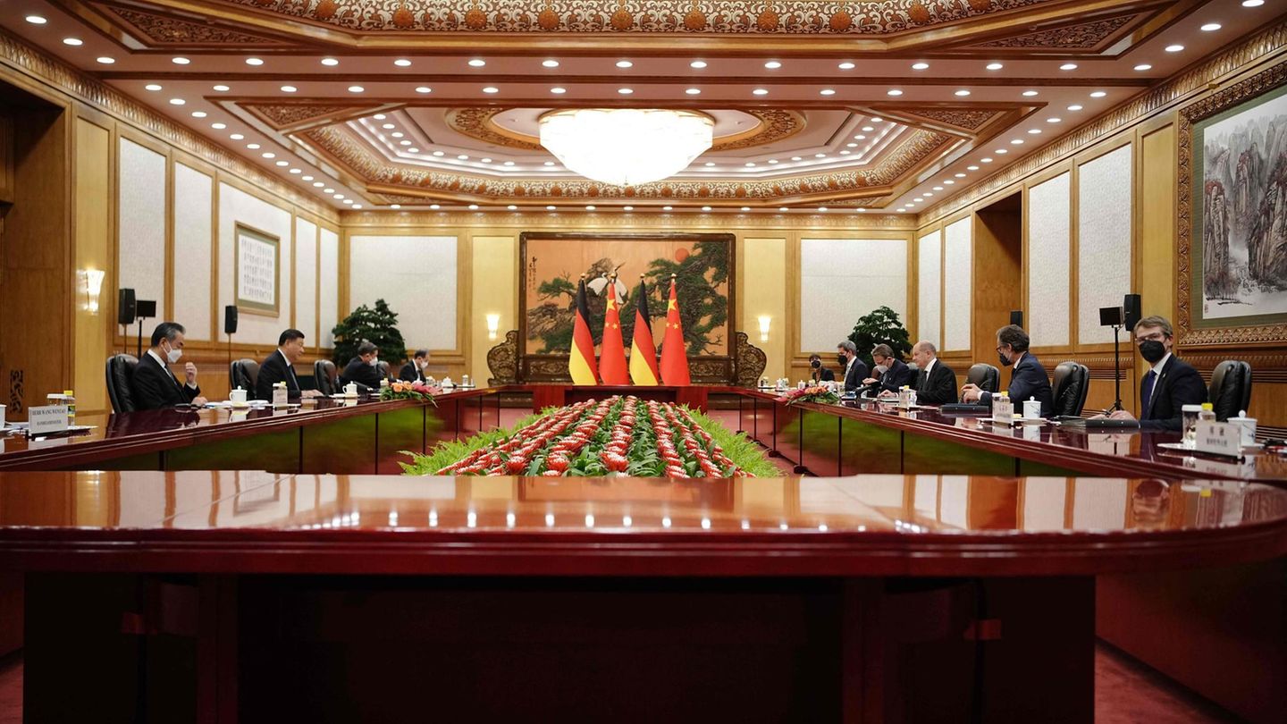 Xi Jinping und Olaf Scholz sitzen an einem großen Tisch