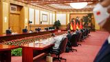 Xi Jinping und Olaf Scholz sitzen gemeinsam an einem großen Tisch