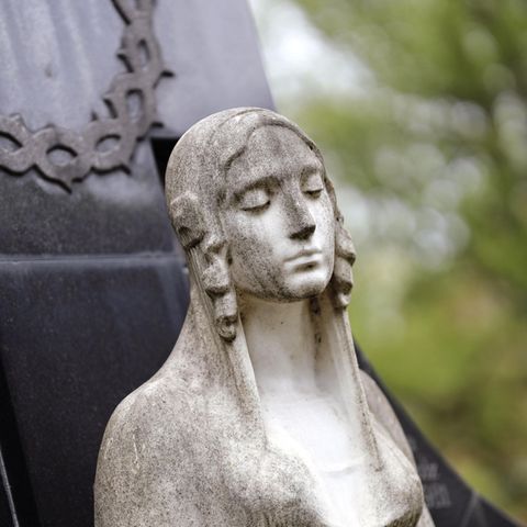 Engelsfigur vor Grabstein Engelsfigur vor Grabstein