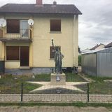 Modell der Freiheitsstatue auf einem beigefarbenen Kiesbett