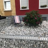 Rosafarbener Liegestuhl auf Schotterfläche