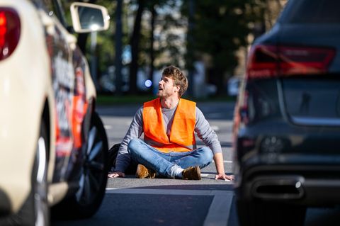 Klimaaktivist klebt sich an Straße