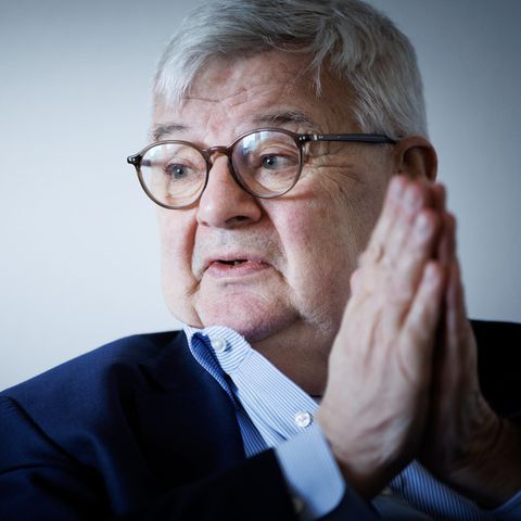 Joschka Fischer mit gefalteten Händen und blickt nach rechts