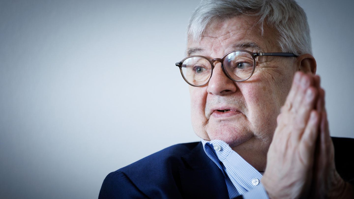 Joschka Fischer mit gefalteten Händen und blickt nach rechts