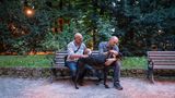 Mauro und Alessandro mit ihren Hunden Eragon und Fiaba auf einer Parkbank