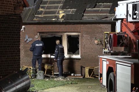 Polizei und Feuerwehr vor dem ausgebrannten Haus