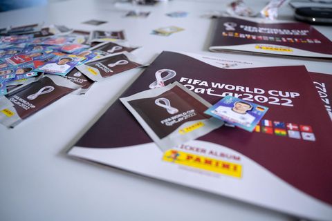 Ein Panini-Sammelheft zur WM 2022, daneben Panini-Sticker