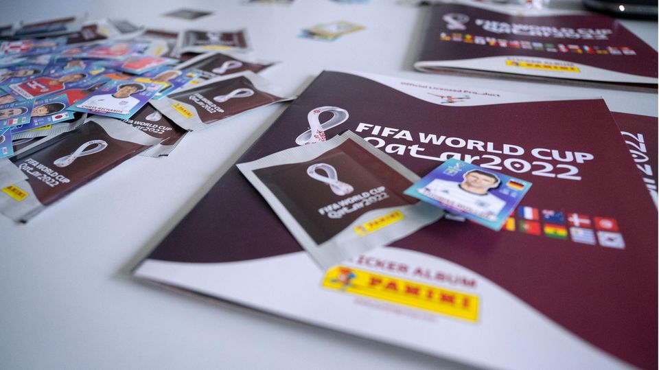 Ein Panini-Sammelheft zur WM 2022, daneben Panini-Sticker