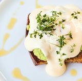 Egg Benedict      BROT  • 4 Scheiben Roggen- oder Dinkelbrot  • etwas Olivenöl      AVOCADO  • 2 Avocados  • Salz  • frisch gemahlener  schwarzer Pfeffer  • Chiliflocken  • Saft von 1⁄2 Zitrone      POCHIERTE EIER  • 500 ml Wasser  • 50 ml weißer Balsamicoessig  • Salz  • 4 Bio-Eier      OLIVENÖL-HOLLANDAISE  • 2 Bio-Eier  • 3 EL weißer Balsamicoessig  • 80 ml Olivenöl  • Salz      BROT  Die Brotscheiben in Olivenöl kräftig anrösten.      AVOCADO  Die Avocados halbieren und das Fruchtfleisch mithilfe eines Löffels aus der Schale kratzen. Nun die Avocados mit einer Gabel grob zerdrücken und mit Salz, Pfeffer, etwas Chili und Zitronensaft ab- schmecken.      POCHIERTE EIER  500 ml Wasser mit ca. 50 ml weißem Balsamicoessig aufkochen und leicht salzen. Die Eier nun einzeln in jeweils eine kleine Schüssel aufschlagen. Anschließend in das leicht siedende Wasser geben und das Eiweiß mithilfe eines Löffels um das Eigelb schlagen. Die Eier für ca. 2–3 Minuten im Wasserbad garen und dann mit einer Schaumkelle aus dem Wasser nehmen, abtropfen lassen und mit Salz würzen.      OLIVENÖL-HOLLANDAISE  Die beiden Eier trennen und die Eigelbe mit 3 EL weißem Balsamicoessig verquirlen. Die Schüssel auf ein heißes Wasserbad stellen und die Masse so lange weiterschlagen, bis eine cremige Sauce entsteht. Die Schüssel dann vom Wasserbad nehmen, 80 ml zimmer- warmes Olivenöl vorsichtig langsam unterrühren und anschließend mit Salz abschmecken.