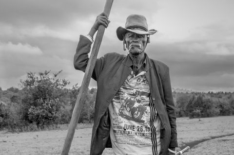 Ein alter Maasai posiert an einen Stab gelehnt