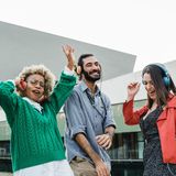 Vier junge Leute tanzen mit Kopfhörern zur Musik.