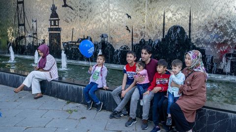 Türkische Familie sitzt an einem Brunnen