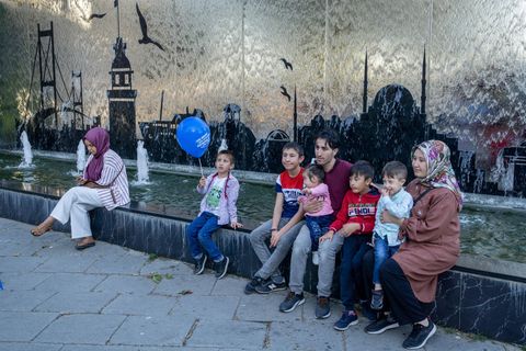 Türkische Familie sitzt an einem Brunnen