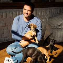 Martin Rütter umgeben von Welpen